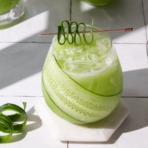 Cucumber ginger drink in a glass with a cucumber garnish