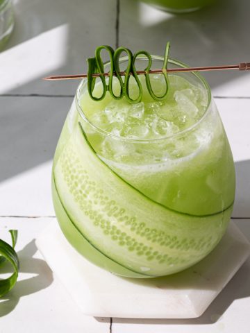 Cucumber ginger drink in a glass with a cucumber garnish