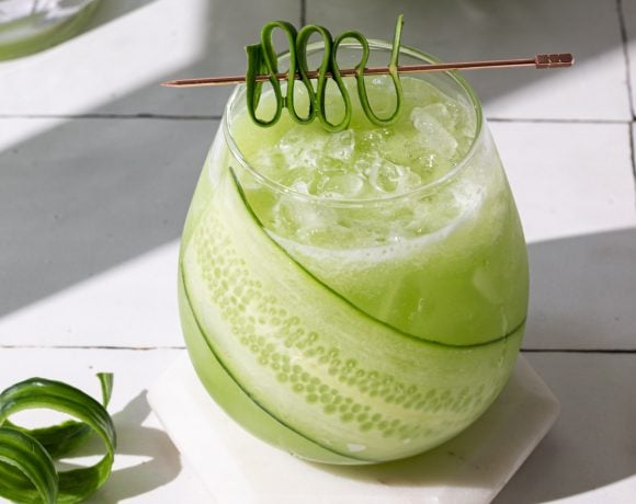 Cucumber ginger drink in a glass with a cucumber garnish