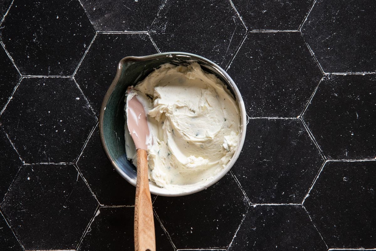 A bowl of goat cheese and butter with a spatula