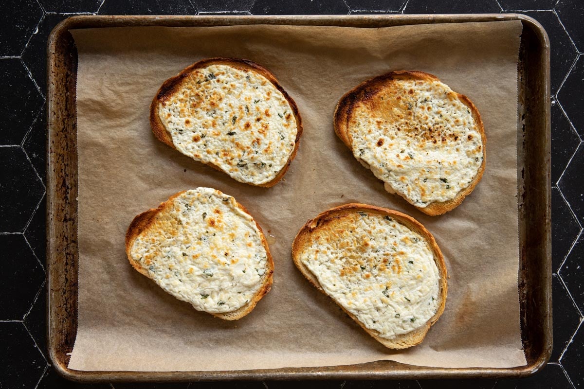 Broiled goat cheese on toasts on a sheet pan