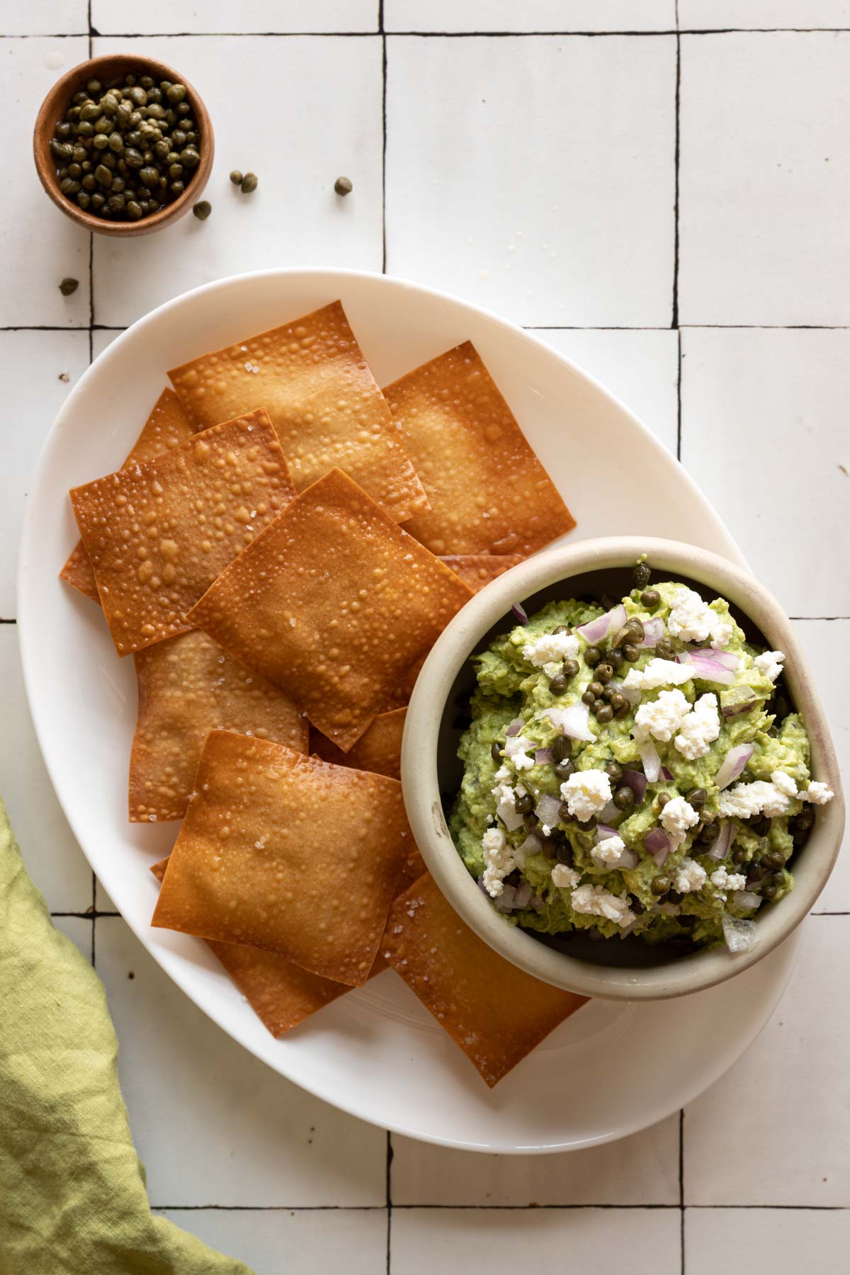 Wonton skins and a bowl of goat cheese guacamole on a plate