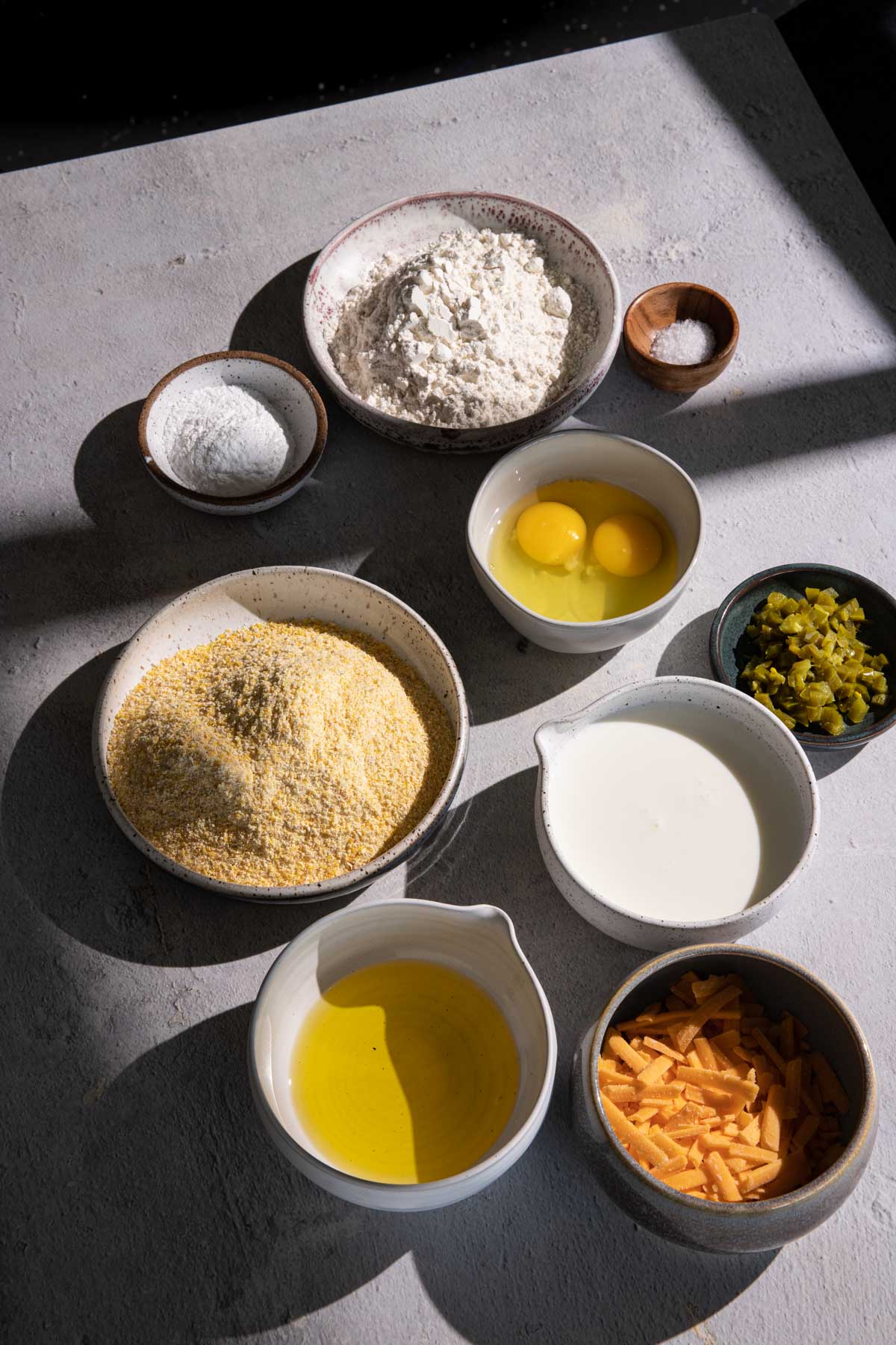 Flour, cornmeal, eggs, cheddar cheese, oil, in separate bowls