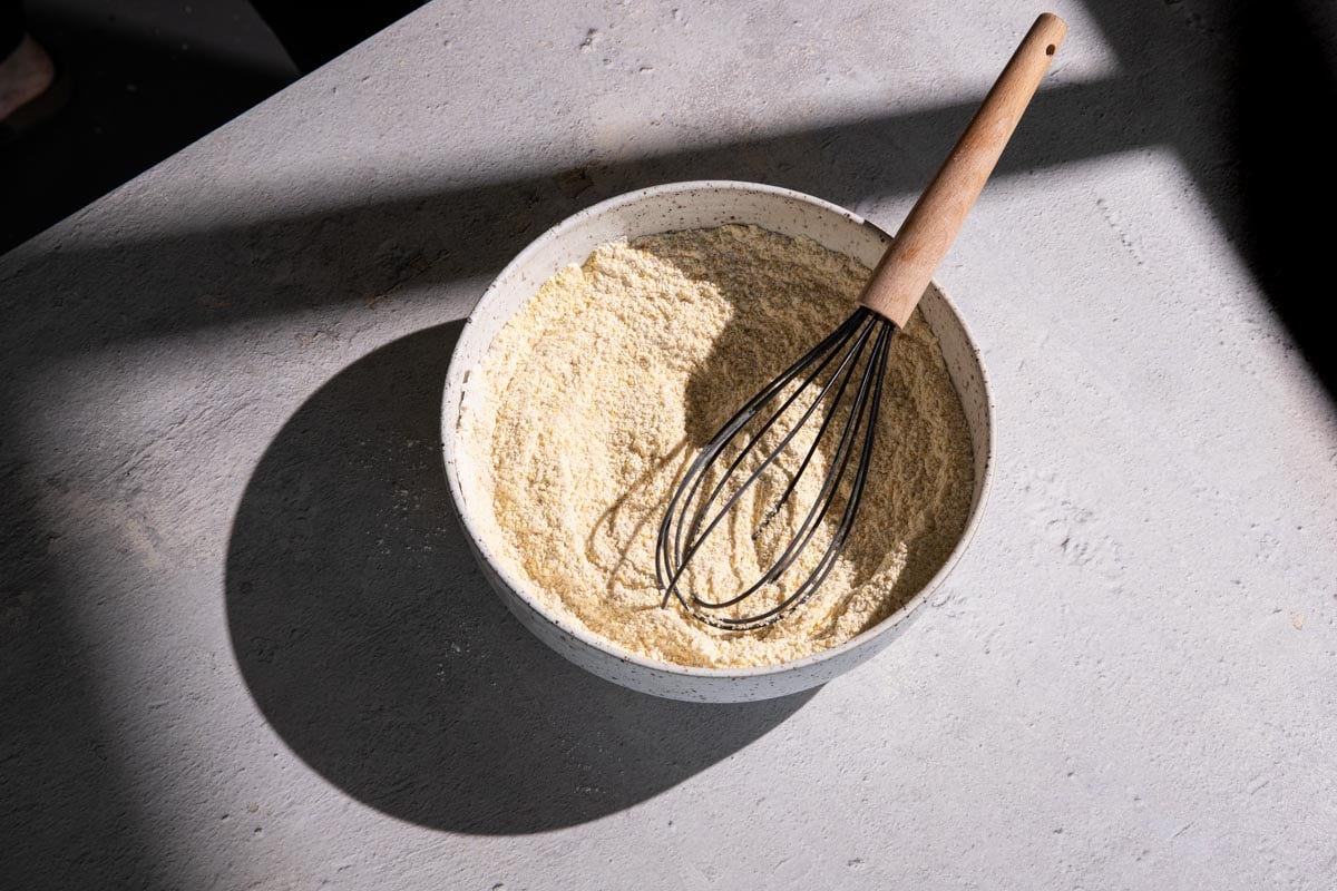 Cornmeal in a bowl with a whisk