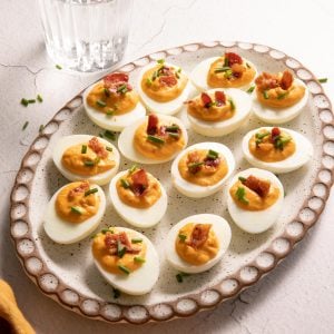 Pimento Bacon Deviled eggs on an oval clay plate