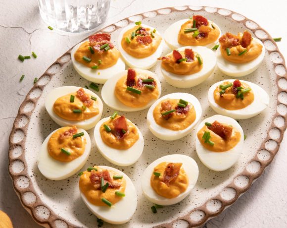 Pimento Bacon Deviled eggs on an oval clay plate