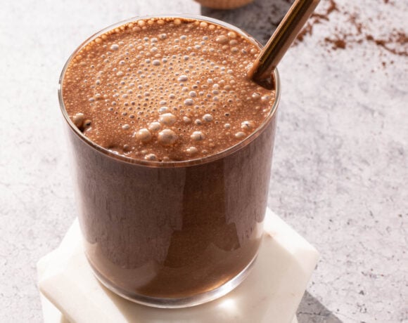 Iced chocolate coffee smoothie in a glass with a metal straw