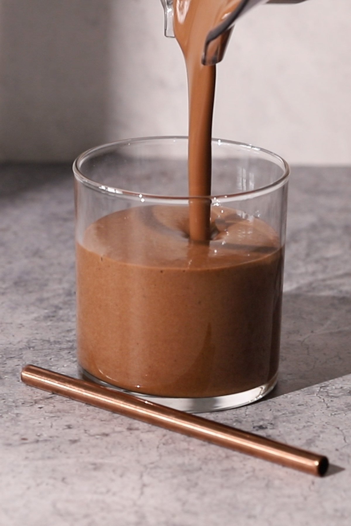 Pouring a chocolate coffee smoothie into a glass