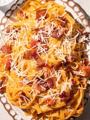 Creamy Tomato bacon pasta on a pottery plate