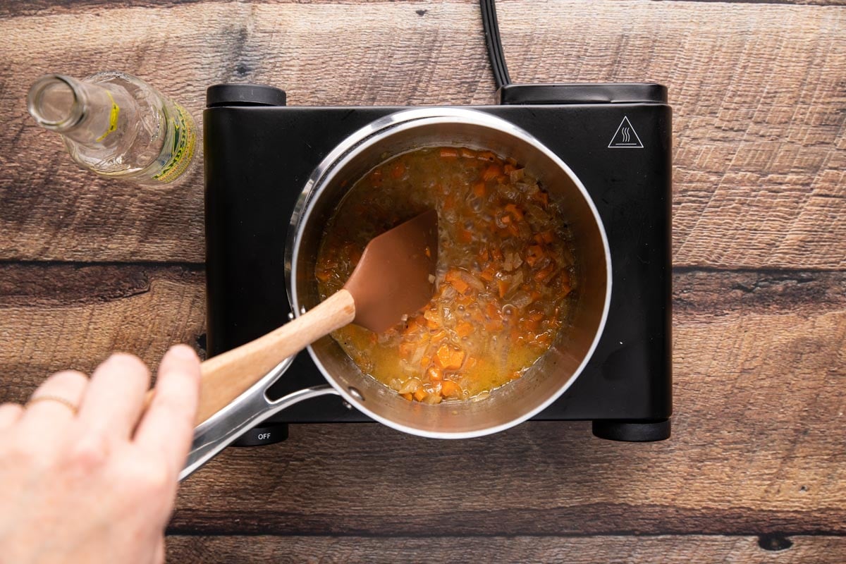 Sauteeing carrots and onions in a pan with a spatula