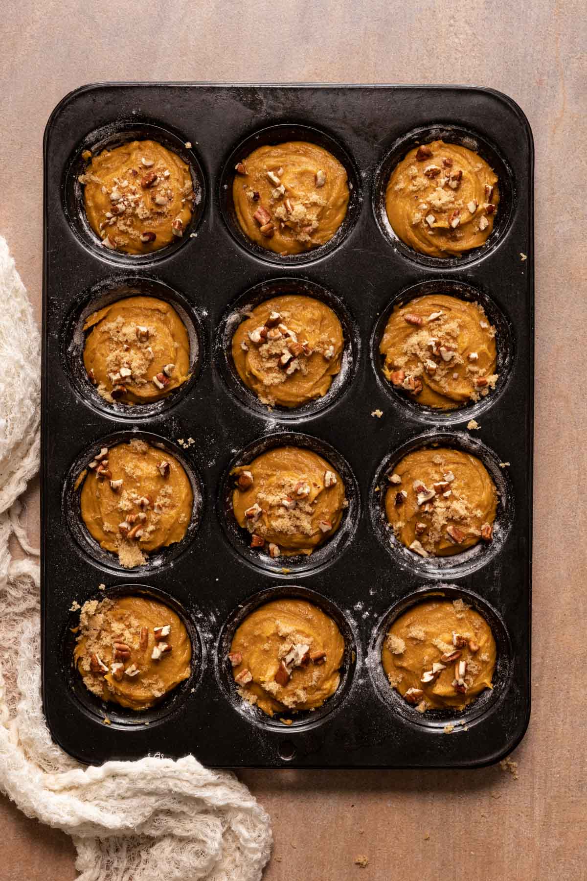 Pumpkin muffins scooped in a black muffin pan
