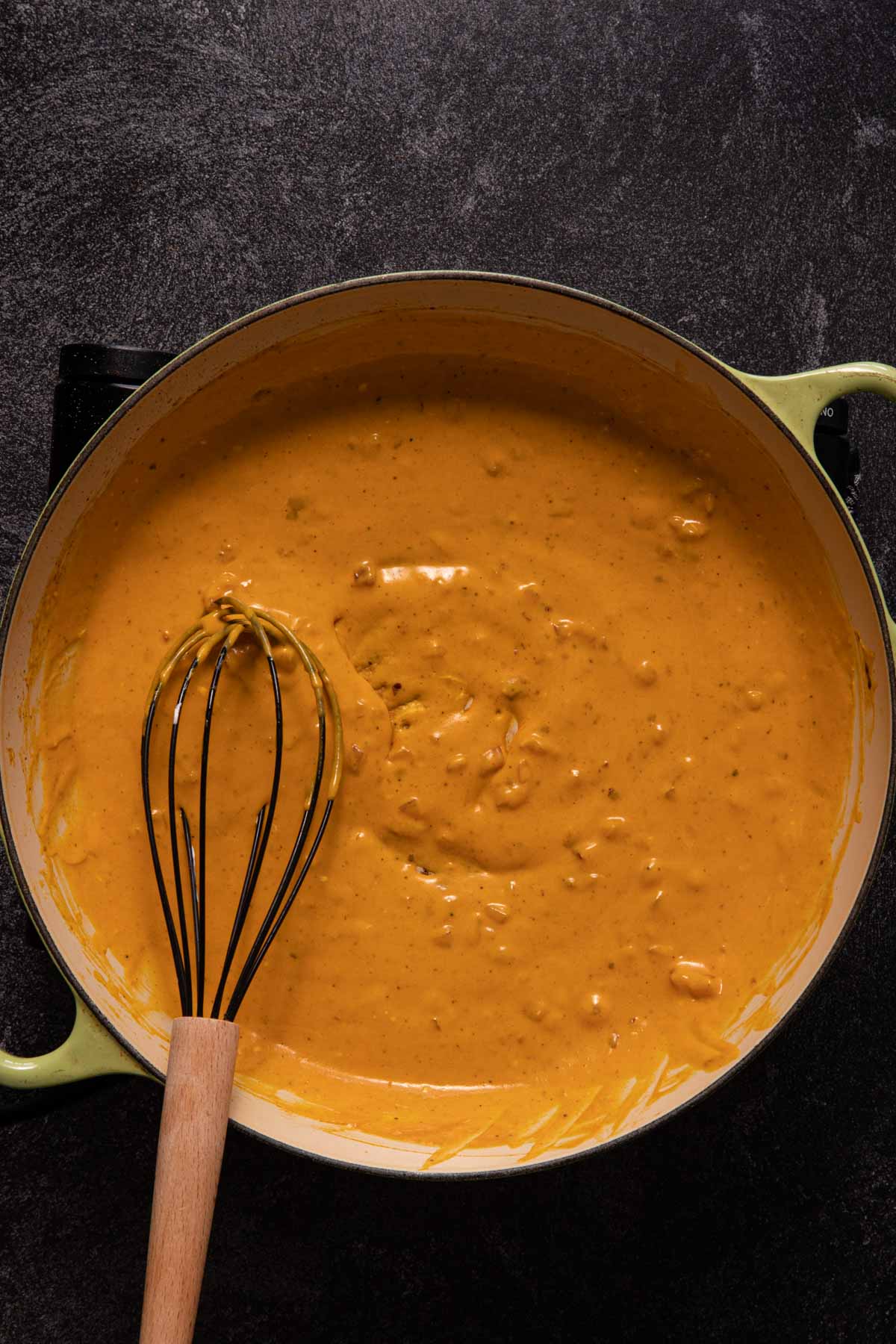 Creamy pumpkin sauce in a saute pan with a whisk
