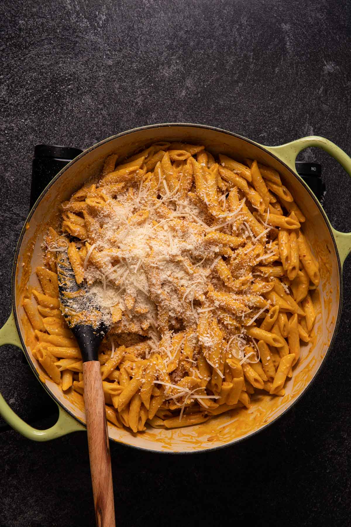 Creamy pumpkin pasta in a saute pan with shredded parmesan