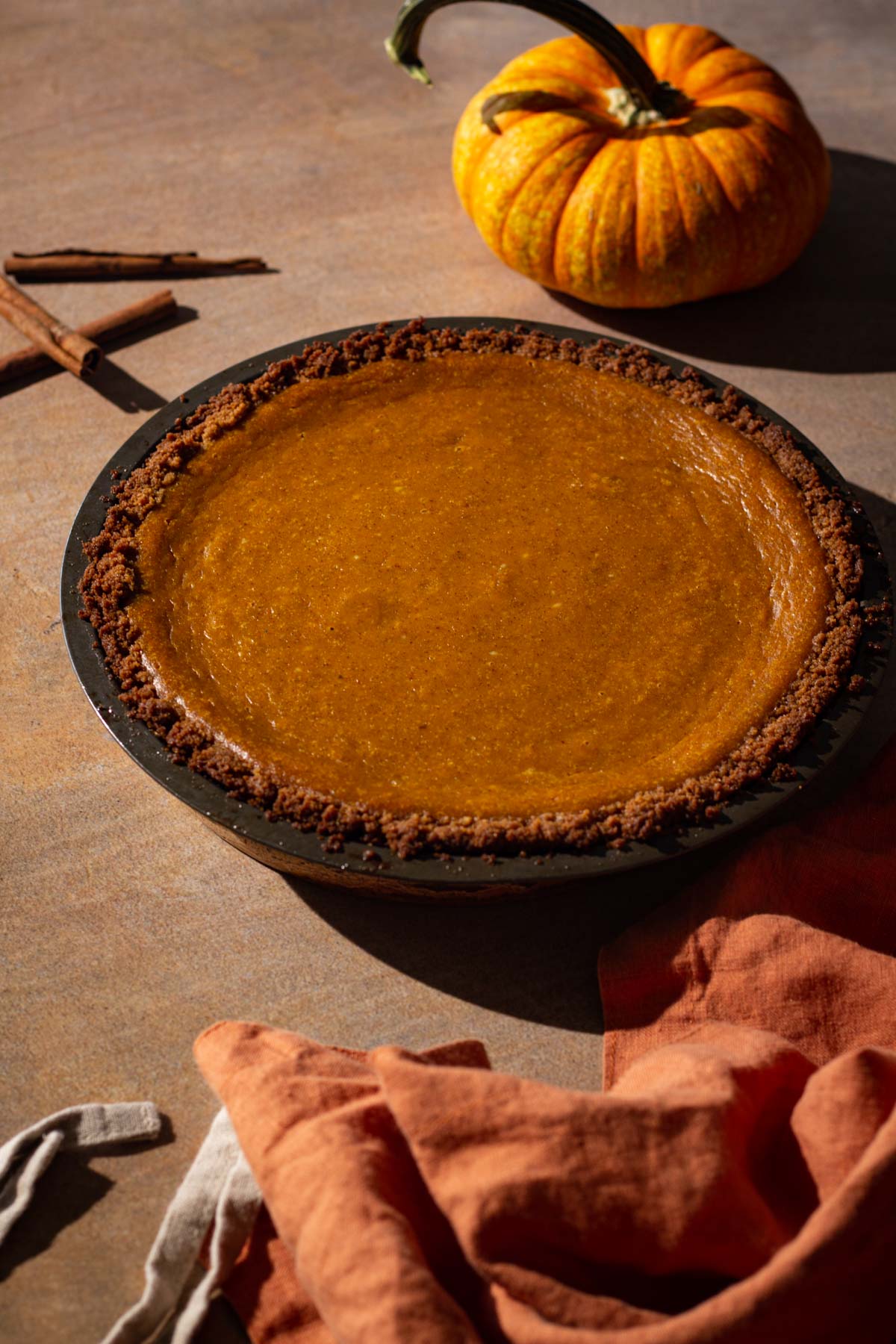 Cream cheese pumpkin pie with a pumpkin and linen napkin