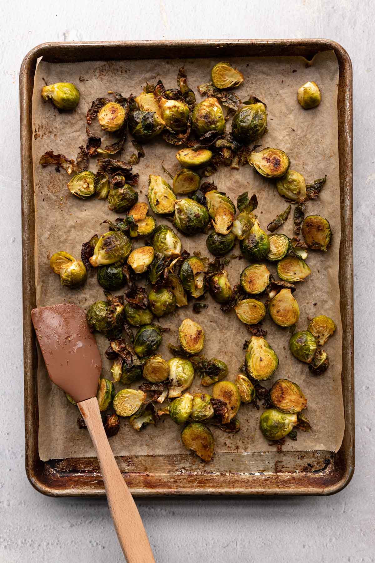 Baked Brussel Sprouts with a spatula on a sheet pan