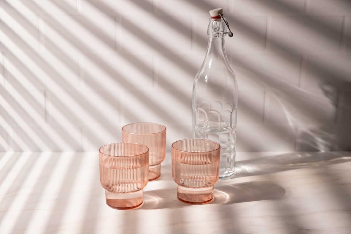 pink glasses in light with window blind shadows