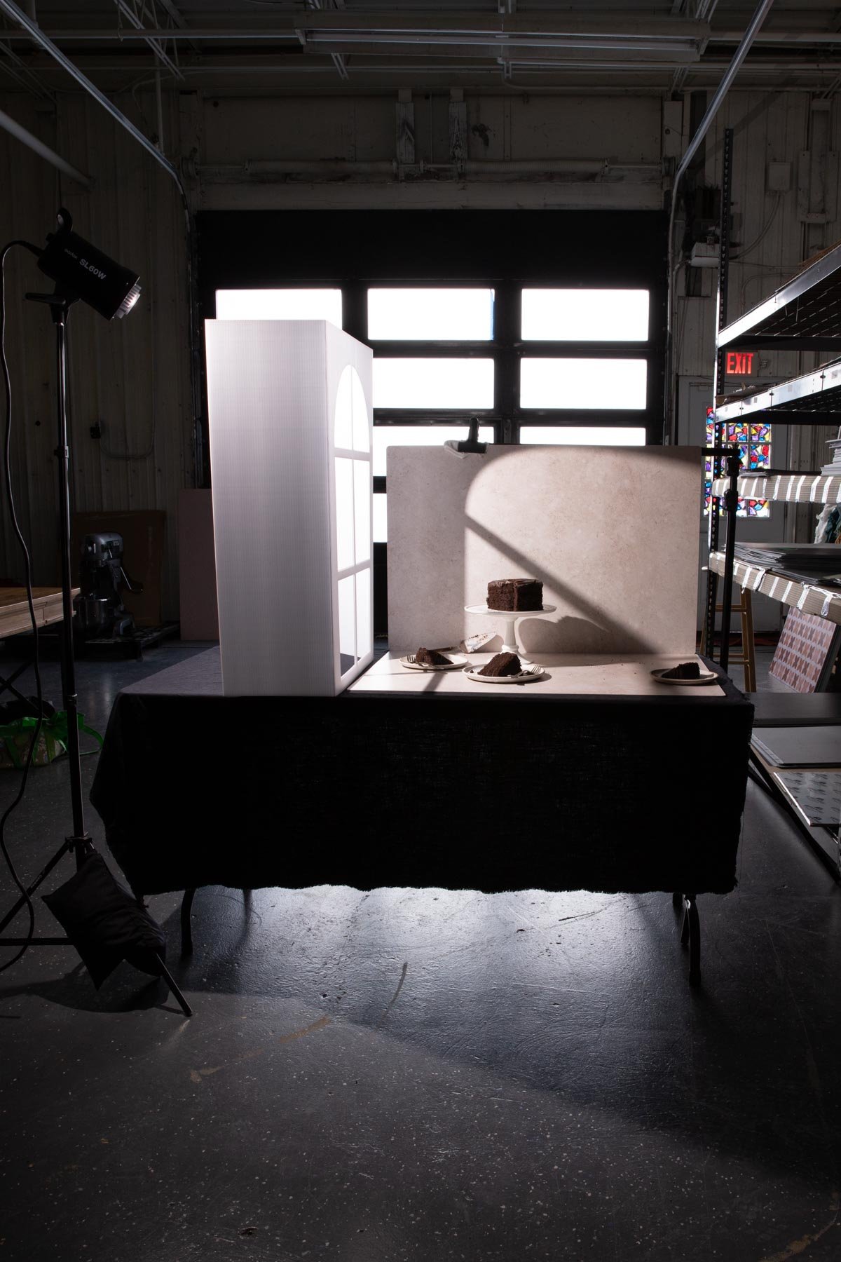 Behind the scenes of a chocolate cake photo with a faux window with shadows