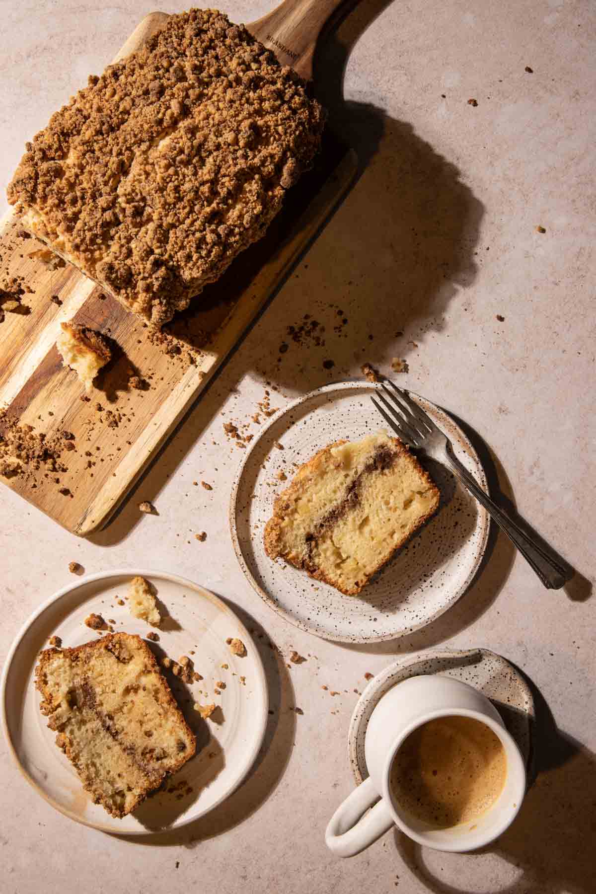 Slices of apple streusel cake on plates with coffee