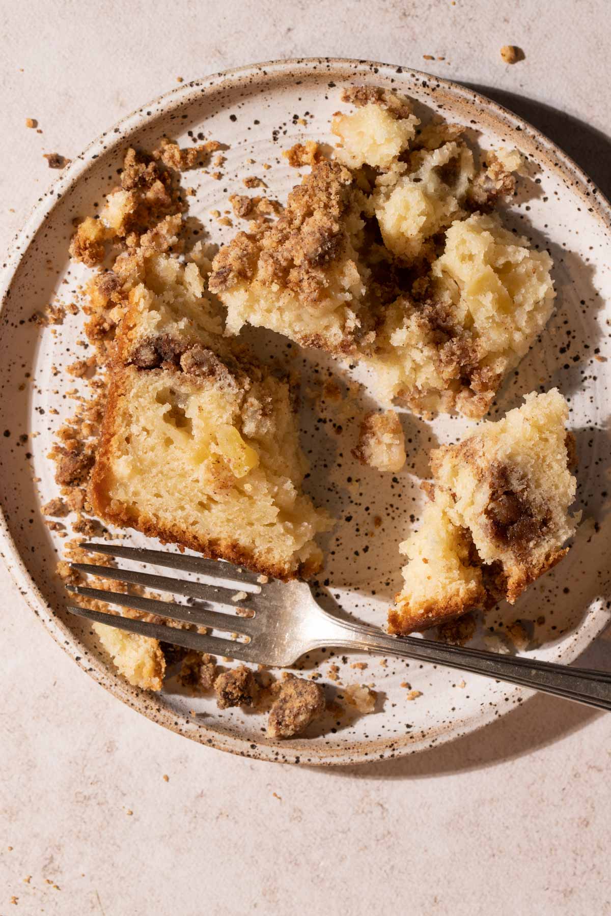 Pieces of apple streusel cake on plate with a fork