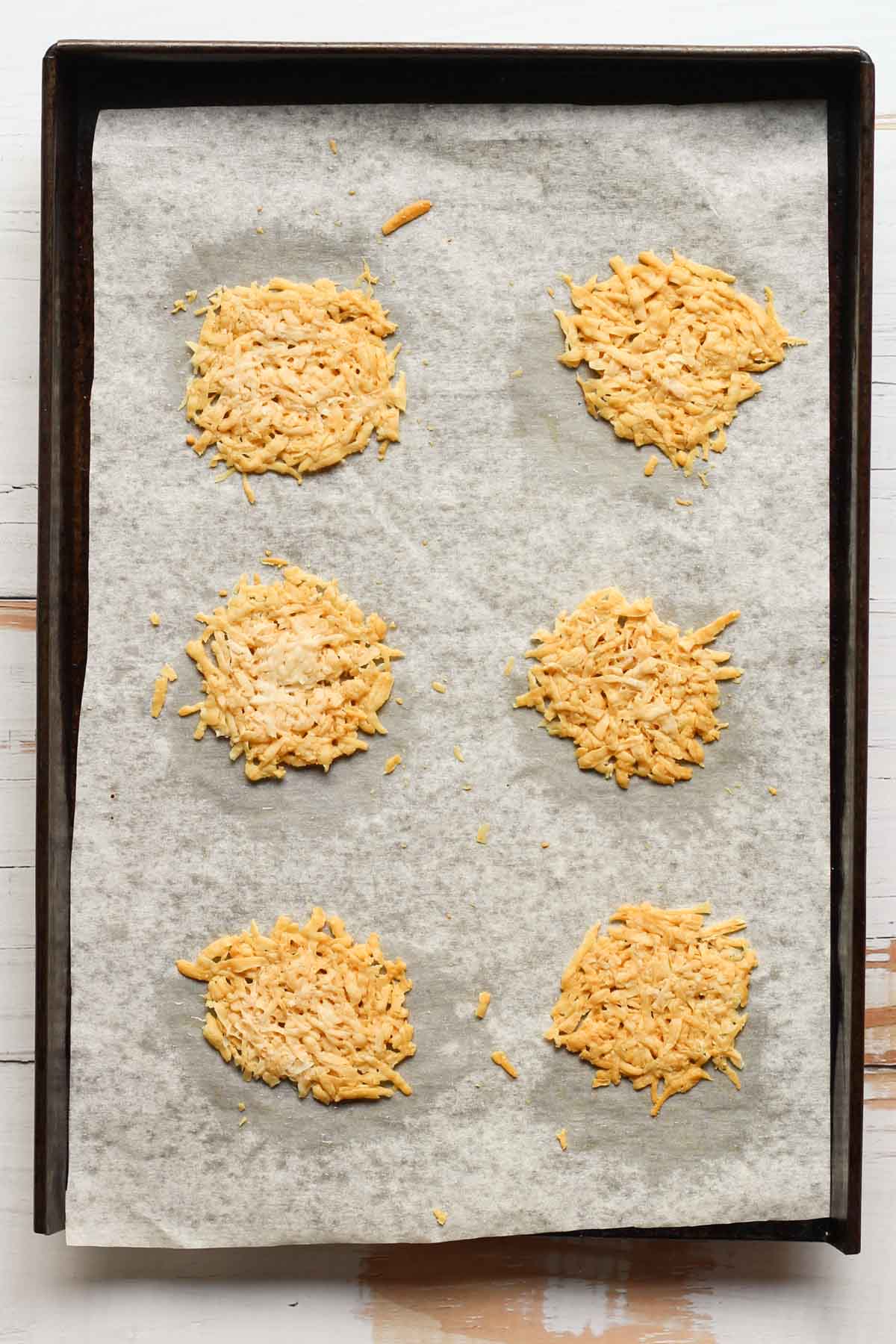 Baked pecorino Romano cheese crisps on a sheet pan