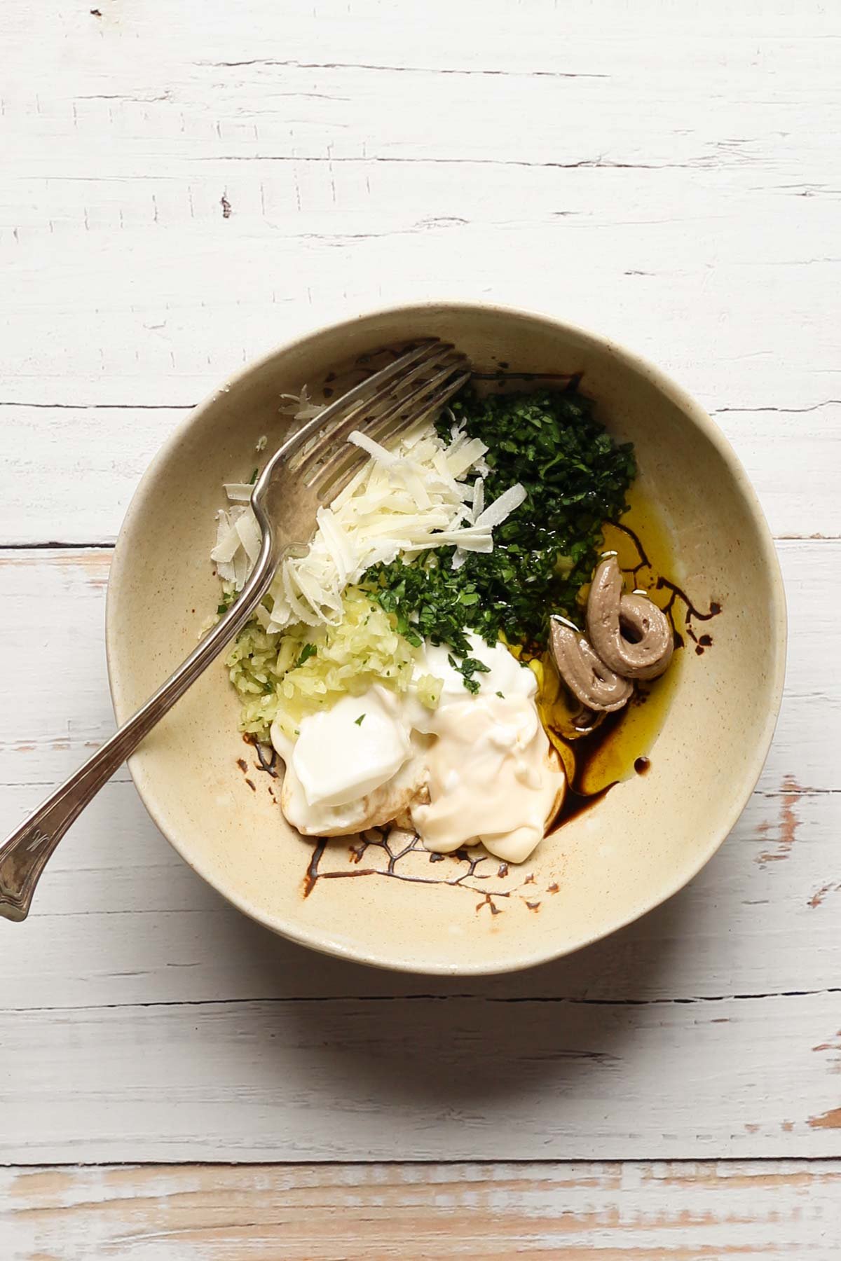 Healthy Caesar dressing ingredients in a bowl with a fork