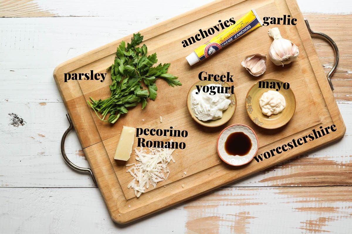Caesar salad dressing ingredients on a cutting board