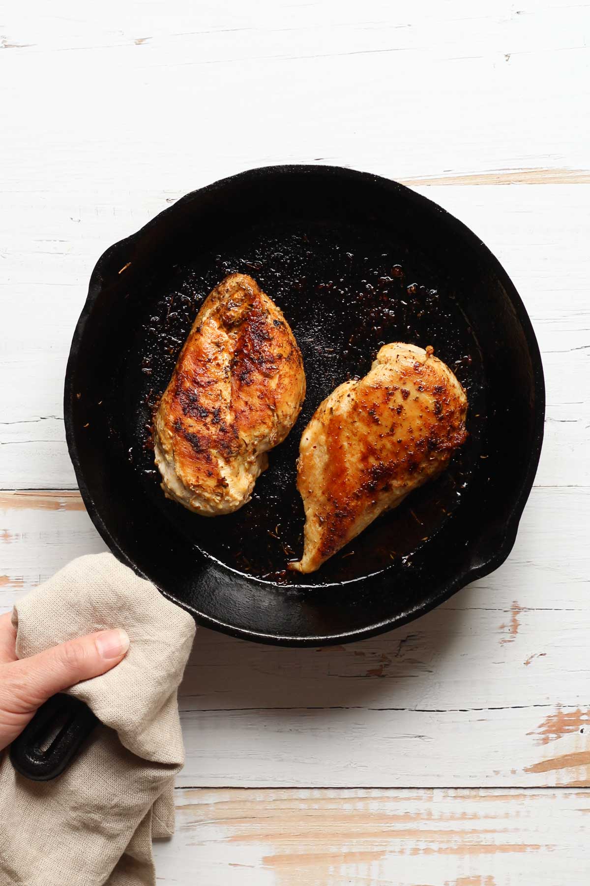 Sauteed chicken breasts in a cast iron skillet