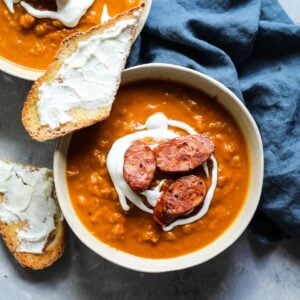 A bowl of Pumpkin butternut squash soup with a piece of goat cheese toast