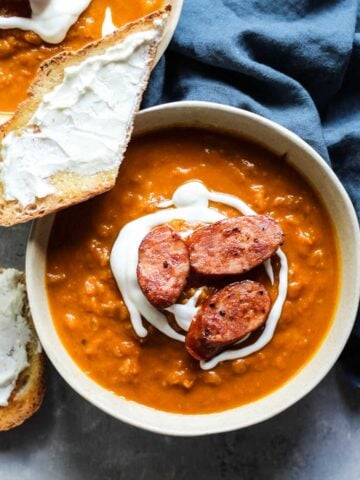 A bowl of Pumpkin butternut squash soup with a piece of goat cheese toast