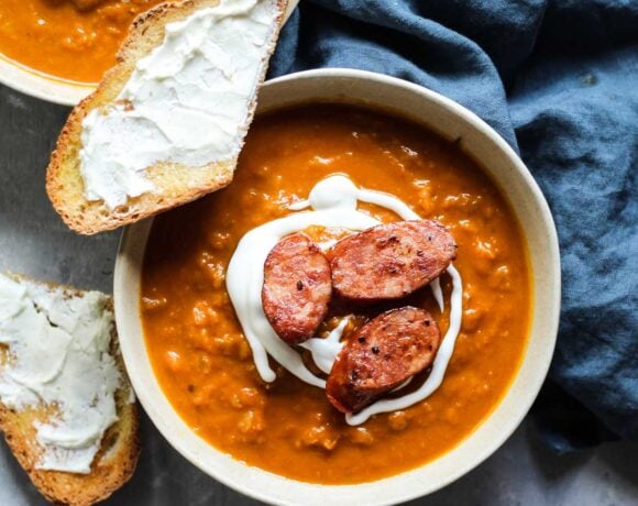 A bowl of Pumpkin butternut squash soup with a piece of goat cheese toast