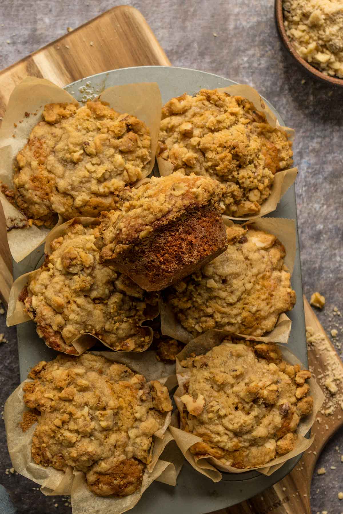 Muffins with streusel topping on top of a muffin pan