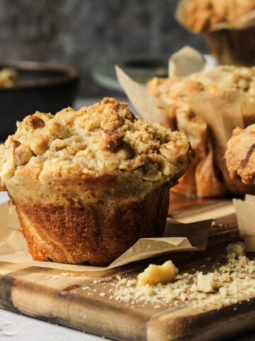 Banana muffins with a streusel topping on a cutting board