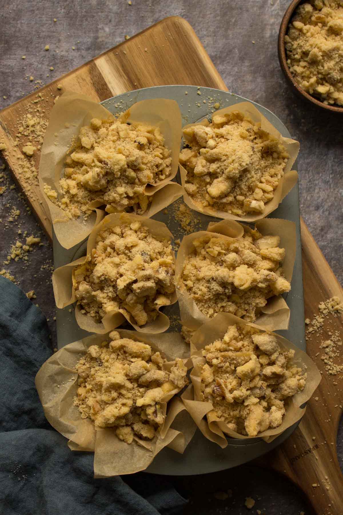 Muffins in a muffin pan topped with streusel