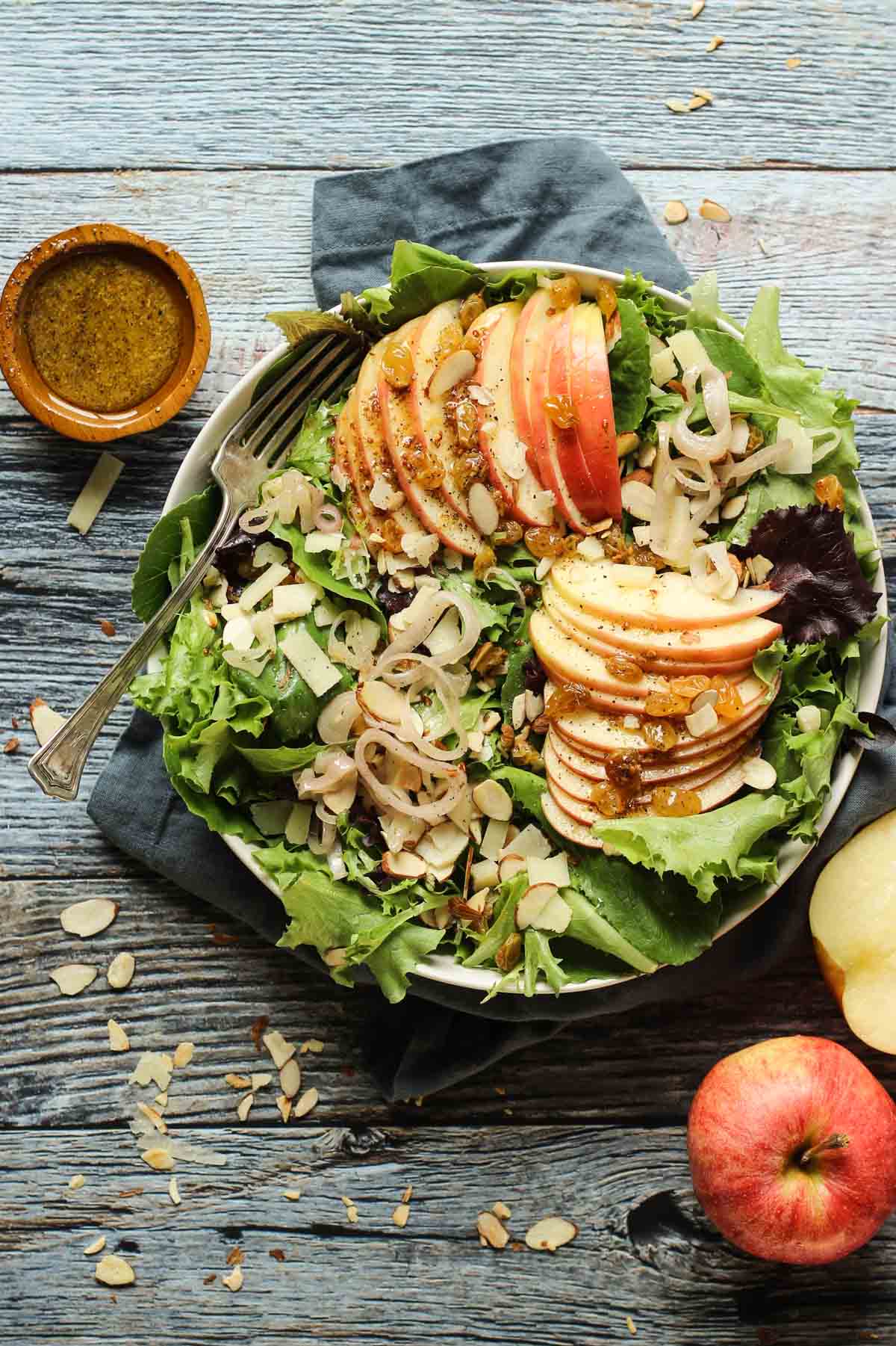 An apple salad in a bowl with shallots and almonds