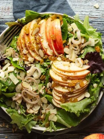 An apple salad with shallots and almonds in a large bowl