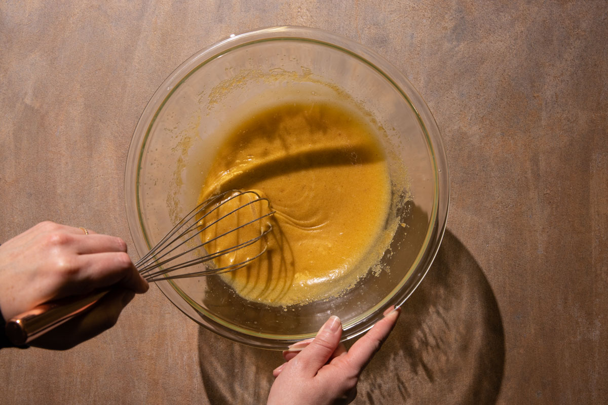 Browned butter and brown sugar in a bowl being whisked