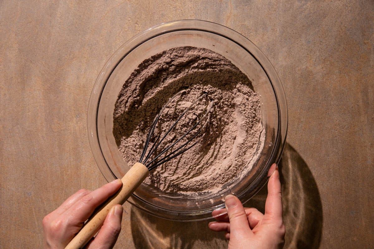 Flour and cocoa powder in a bowl being whisked