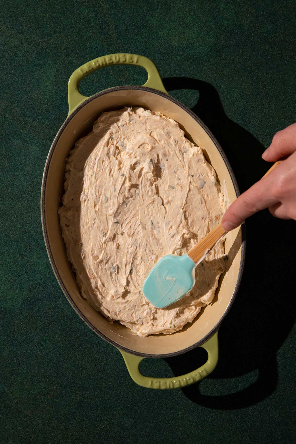 The creamy goat cheese dip mixed up and in a baking dish to be baked.