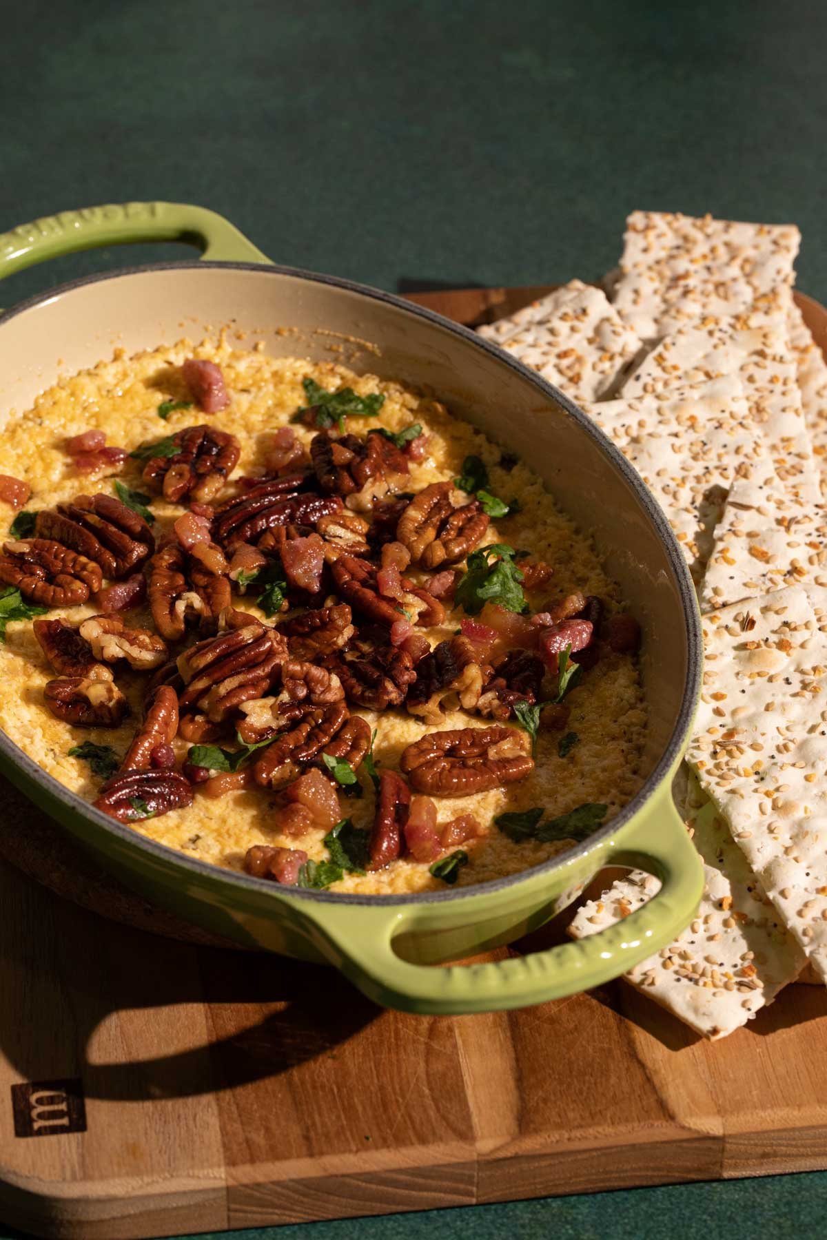 Goat cheese dip with toasted pecans in a ceramic baking dish