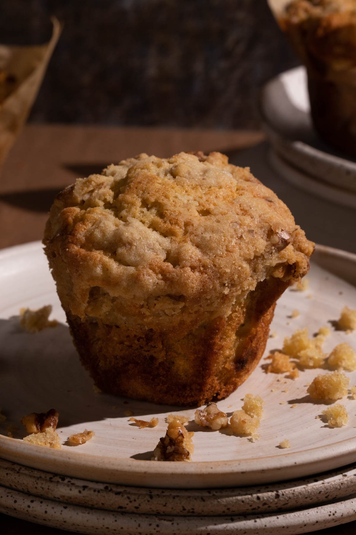 A banana walnut muffin on a stack of plates