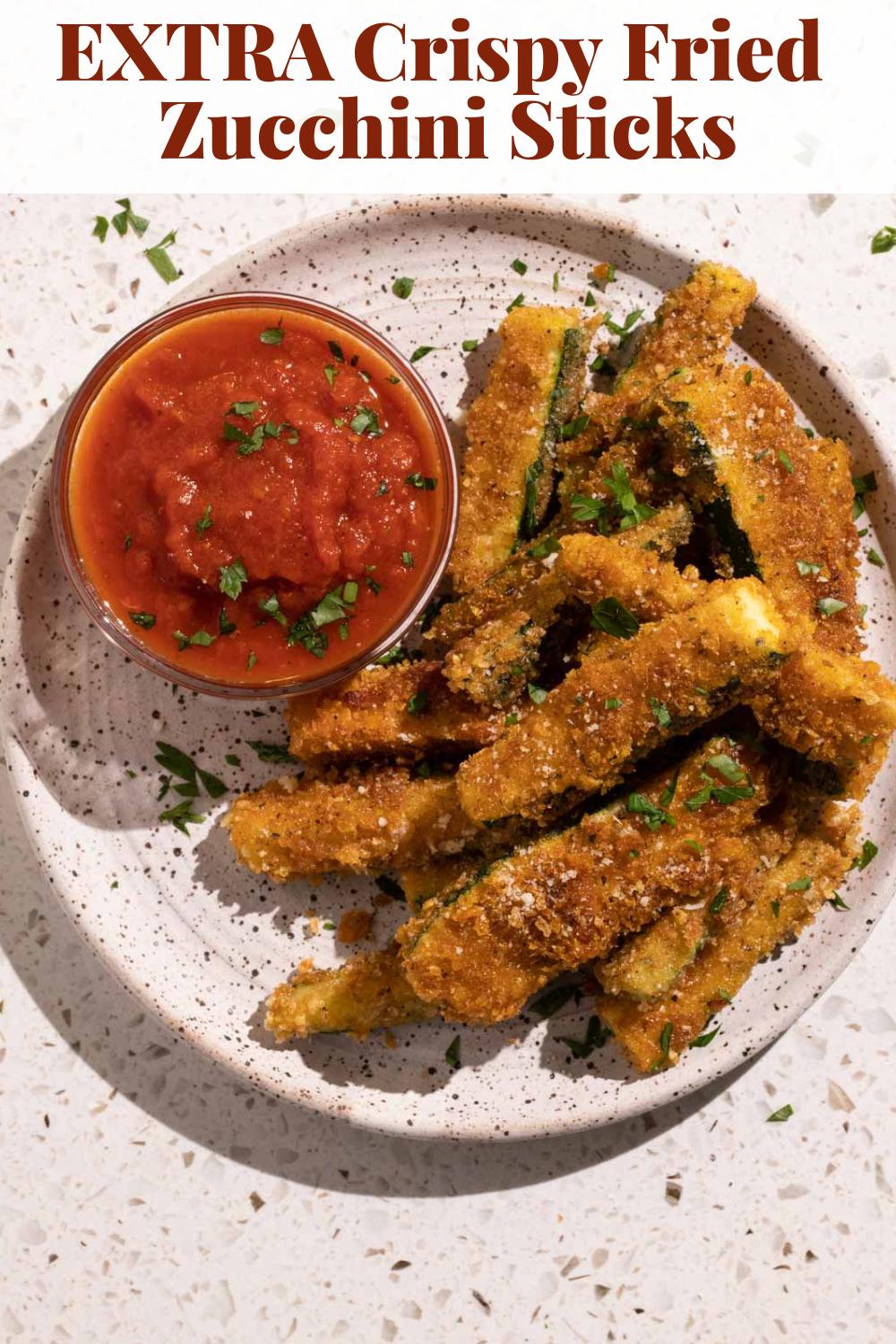 A plate of crispy fried zucchini sticks with marinara sauce via @bessiebakes