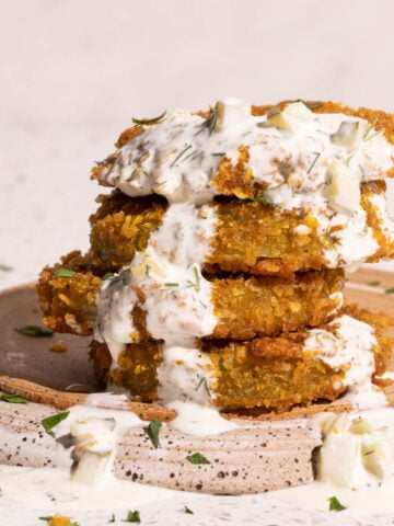 Fried green tomatoes with dill pickle ranch dip drizzled on top