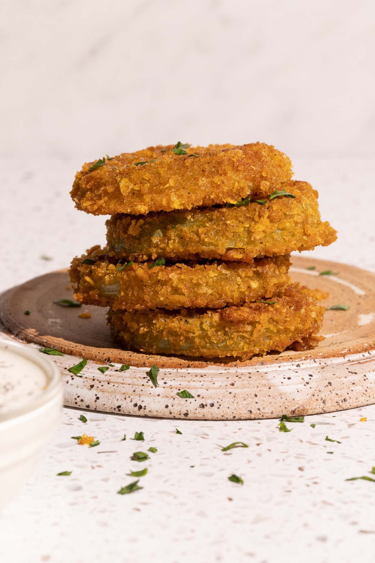 Fried green tomatoes stacked with dill pickle ranch in a bowl