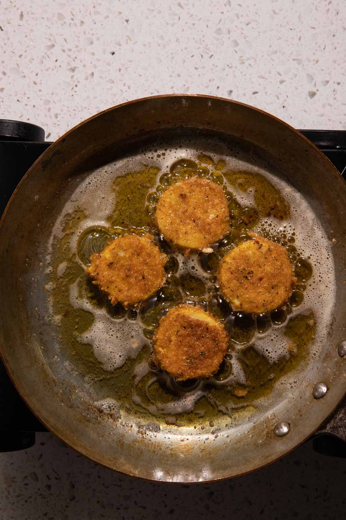 fried squash frying in a pan with oil