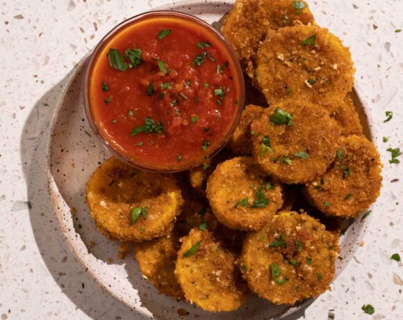 A bowl of marinara and a plate of fried squash